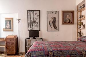 パルマにあるStudio Borgo Colonneのベッドルーム1室(ベッド1台付)が備わります。壁には絵画が飾られています。
