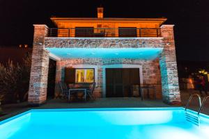 uma villa com piscina à noite em Villa Dino em Lukoran