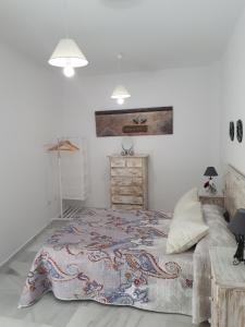 サンルーカル・デ・バラメダにあるMarelenaの白いベッドルーム(大型ベッド1台、ドレッサー付)