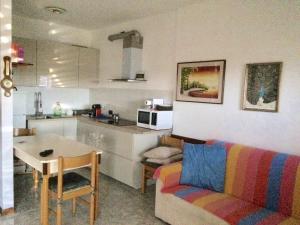 a kitchen and a living room with a couch and a table at Appartamento - terrazzo vivibile vista mare, wi-fi gratuito in Vallecrosia