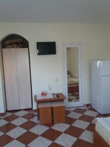- un salon avec une table et un réfrigérateur dans l'établissement Vila Sunset, à Eforie Nord