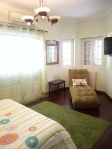 una camera da letto con un letto, un divano e una sedia di Casa do Trovador a Serra