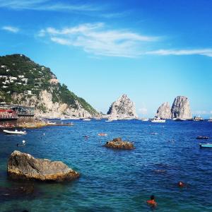 um grupo de pessoas nadando na água com pedras em Apartment Stella Maris em Capri