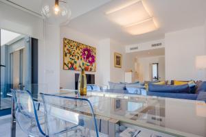 Una sala de estar con una mesa de cristal y un sofá. en Apartamentos Bahía Blanca, en El Puerto de Santa María