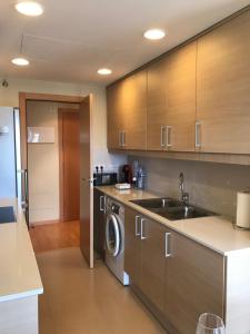 a kitchen with a sink and a washing machine at Duplex in Santa María de Barbará
