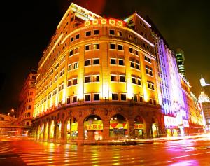 a building with lights on the side of it at night at Xin Hua Hotel Guangzhou in Guangzhou