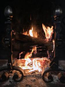 un camino aperto con fiamme di Les Hauts de Gageac Maison d'Hôtes de Charme a La Roque-Gageac