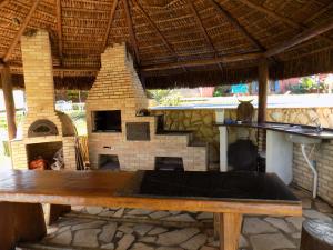 a wooden table in front of a brick fireplace at Pousada Rural Paraíso in Águas de São Pedro