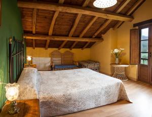 Casa de Aldea Carboneiro في Naraval: غرفة نوم بسرير كبير وسقف خشبي