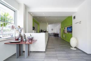 um corredor com uma mesa e uma cozinha com paredes verdes em Bel Soggiorno em Rimini