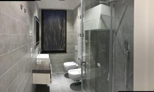 e bagno con servizi igienici e doccia in vetro. di Venetian Aesthetic Apartment a Mestre