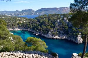 a lake in the mountains with blue water and trees at La douceur de Cassis in Cassis