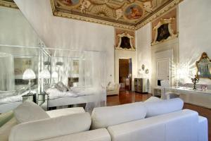 Elle comprend un salon doté d'un mobilier blanc et d'un plafond. dans l'établissement Palazzo Tolomei - Residenza D'Epoca, à Florence
