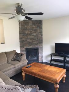 un salon avec un canapé, une table et une cheminée dans l'établissement Victoria Harbour Cottages, à Victoria Harbour