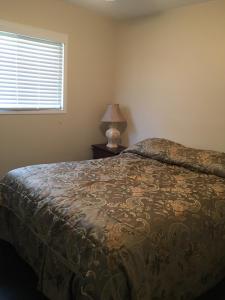 une chambre avec un lit, une lampe et une fenêtre dans l'établissement Victoria Harbour Cottages, à Victoria Harbour