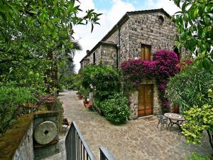a stone house with flowers on the side of it at La Neffola Residence in Sorrento
