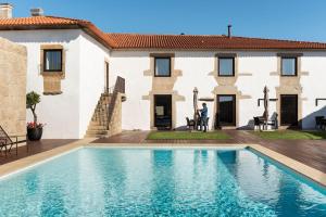 a man standing in front of a house with a swimming pool at Casa de Santa Cruz in Felgar