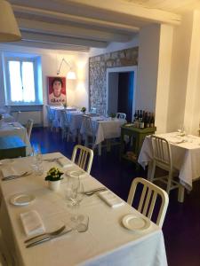 uma sala de jantar com mesas brancas e cadeiras com roupa de mesa branca em Locanda Rocco em Sirolo