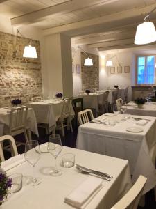 un ristorante con tavoli e sedie bianchi con biancheria da tavolo bianca di Locanda Rocco a Sirolo