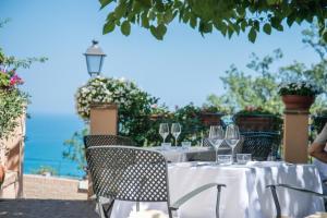 a table with wine glasses and a view of the ocean at Locanda Rocco da Francesco in Sirolo