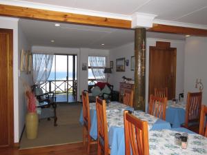 a dining room with tables and chairs with a view of the ocean at At Whale-Phin Guest House in Reebok