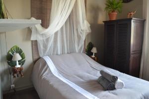 a bedroom with a white bed with a canopy at La douceur de Cassis in Cassis