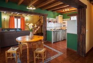 cocina y sala de estar con mesa y nevera en Casa de Aldea Carboneiro, en Naraval