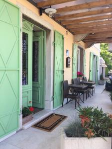 a patio with green doors and tables and chairs at Bed and Breakfast Villa Maria in Lovran