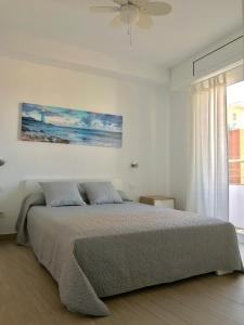 una camera da letto con un letto e un dipinto sul muro di Apartamento cerca del mar (parking incluido) a Blanes