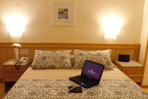 a laptop computer sitting on top of a bed at Hotel Regina Rio de Janeiro in Rio de Janeiro