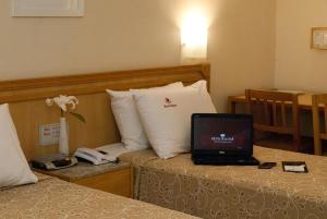 a laptop computer sitting on a bed in a hotel room at Hotel Regina Rio de Janeiro in Rio de Janeiro