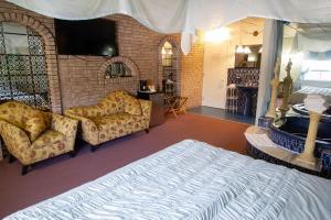 um quarto com uma cama e dois sofás em Auberge La Rocaille em Shawinigan