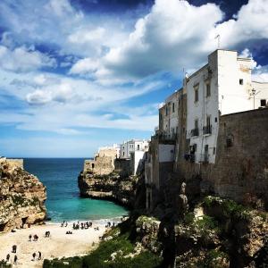 eine Gruppe von Menschen an einem Strand neben dem Meer in der Unterkunft WePuglia - Santo Cosma - La Suite in Polignano a Mare