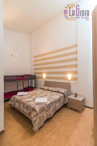 a bedroom with two beds and a striped wall at La Gioia di Sicilia Appartamenti in Avola