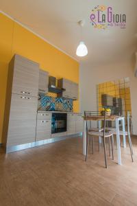 a kitchen with a table and chairs in a room at La Gioia di Sicilia Appartamenti in Avola
