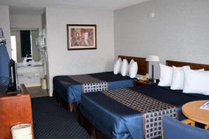 Habitación de hotel con 2 camas y mesa en Bluegrass Extended Stay, en Lexington