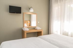 Schlafzimmer mit einem Bett, einem Spiegel und einem Bett in der Unterkunft Creta Elena in Chania