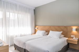 a bedroom with a large bed and a window at Creta Elena in Chania