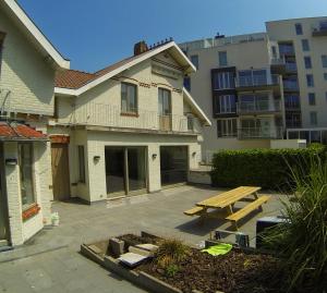 a backyard with a wooden picnic table in front of a house at ons kotje in De Panne