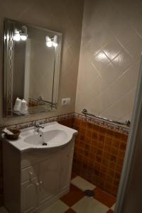 Paterna del Campo的住宿－拉魯塔旅館，一间带水槽和镜子的浴室