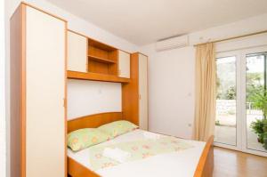 mała sypialnia z łóżkiem i oknem w obiekcie Apartments Skurla w mieście Saplunara +23 zdjęcia
