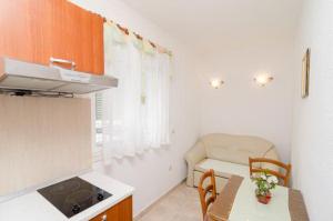 a small kitchen with a table and a chair at Apartments Skurla in Saplunara