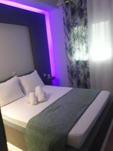 a bedroom with a bed with purple lights on it at Filoxenia Apartments in Skala Sotiros