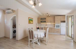 een keuken en eetkamer met een tafel en stoelen bij Apartmani Oaza in Trogir