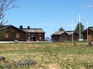 un grupo de edificios de madera en un campo en Knappgården en Särna