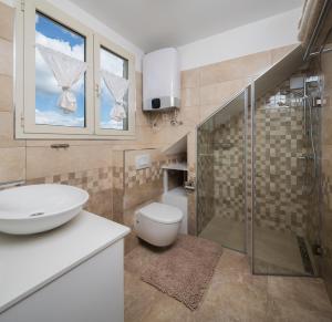 een badkamer met een toilet, een wastafel en een douche bij Apartmani Oaza in Trogir +73 foto's