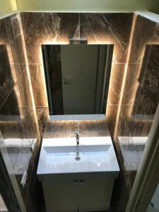 uma casa de banho com um lavatório branco e um espelho. em Hotel Jurgen em Lezhë