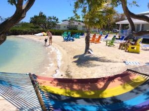 a beach area with a pool, chairs, and benches at Parmer's Resort in Little Torch Key