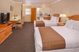 Cayucos Beach Inn في كايوكوس: غرفة فندقية بسريرين وتلفزيون بشاشة مسطحة