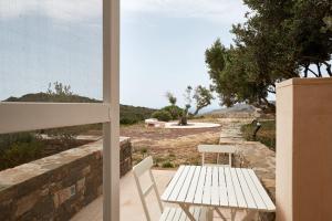 a table and chairs on a patio with a view of the ocean at Studio Julie in Kapsali
